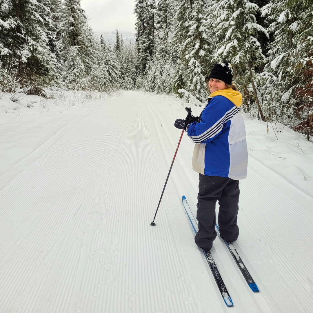 A young woman cross country skiing on a snow-covered trail at Candle Creek using rental skis from Wells Gray Outfitters in Clearwater BC