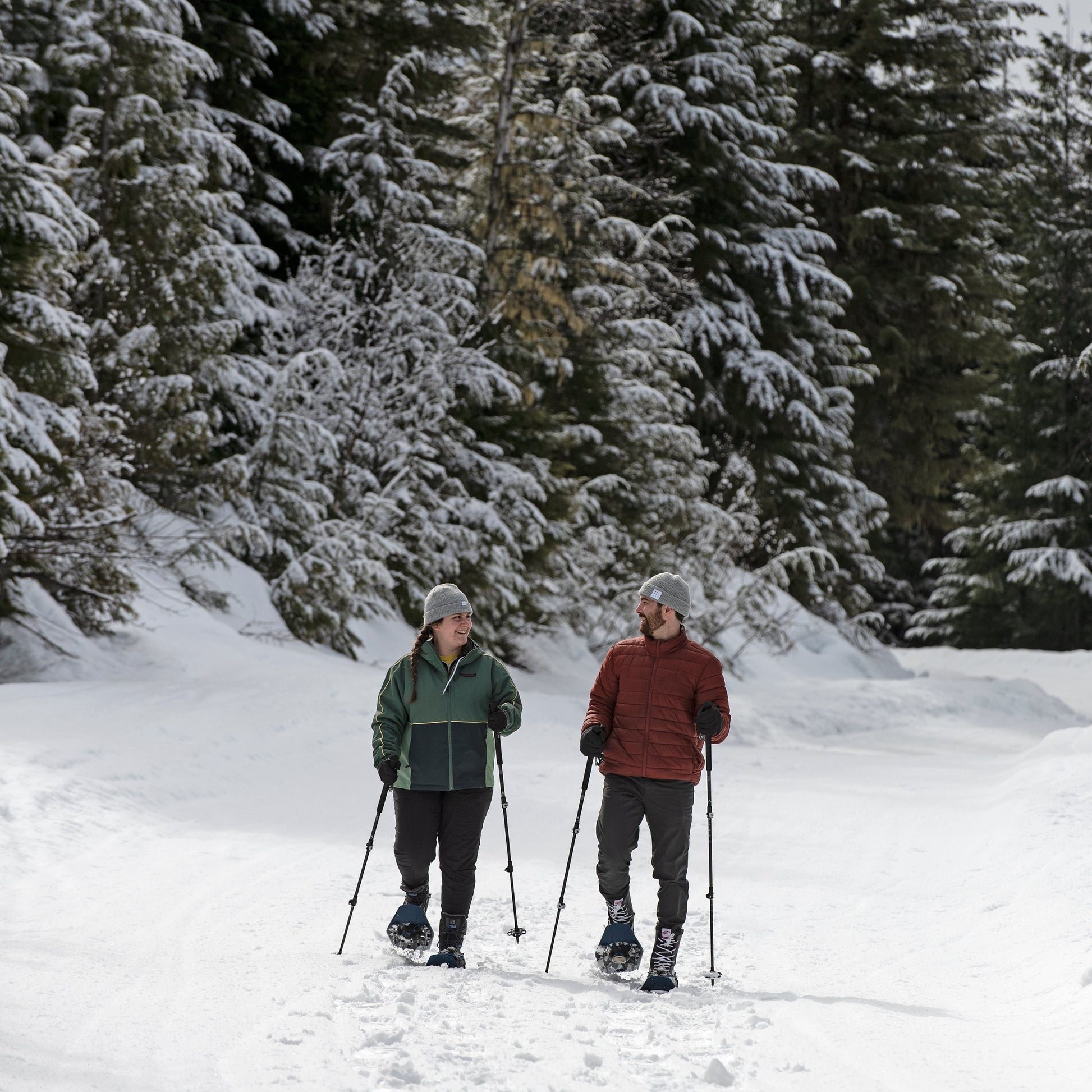Two people snowshoeing on a snowy trail in the forest in Wells Gray Provincial Park