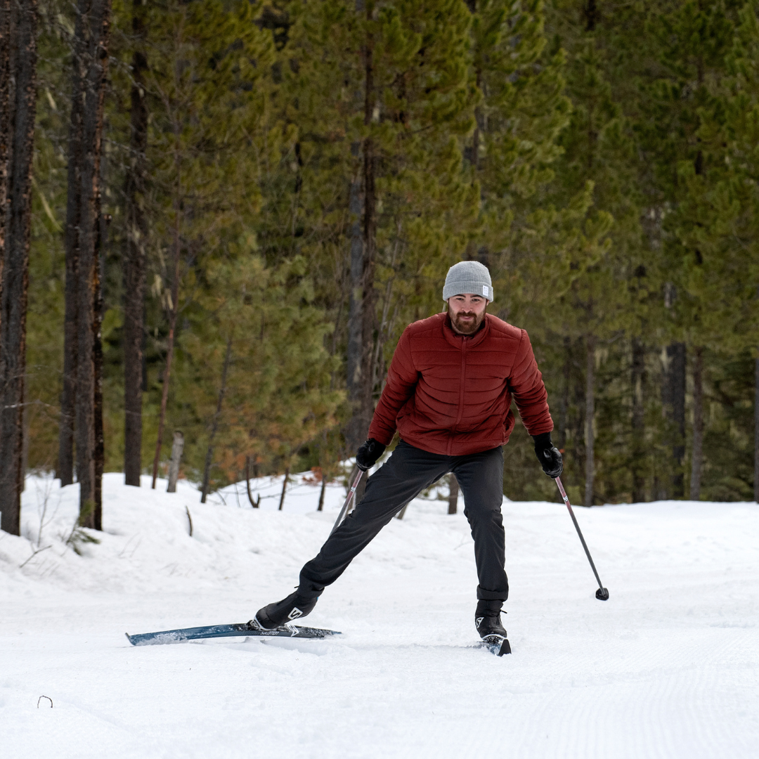 A man skate skiing in a snowy forest at Candle Creek in Clearwater BC using rental skis from Wells Gray Outfitters