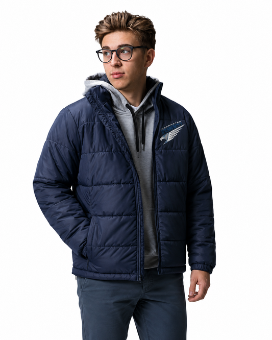 A man wearing a navy blue puffer jacket with a gray hoodie underneath, standing against a plain white background. The jacket features a Clearwater Icehawks logo on the left chest.