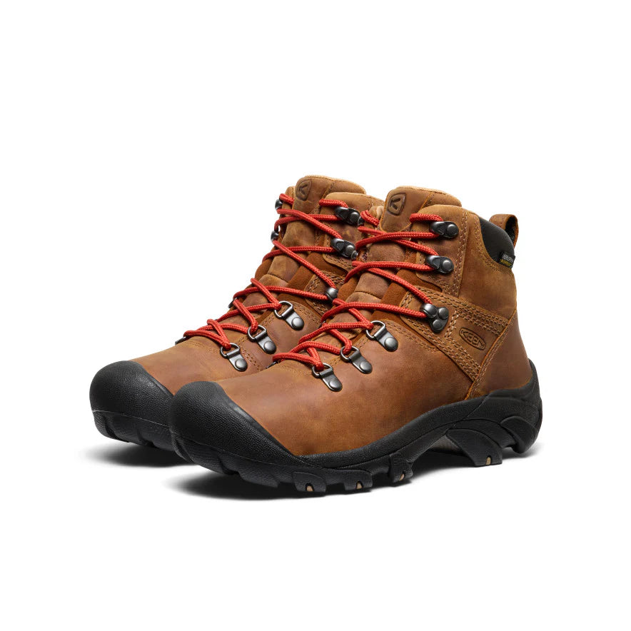 Pair of brown leather Keen womens hiking boots with a black sole and orange laces.