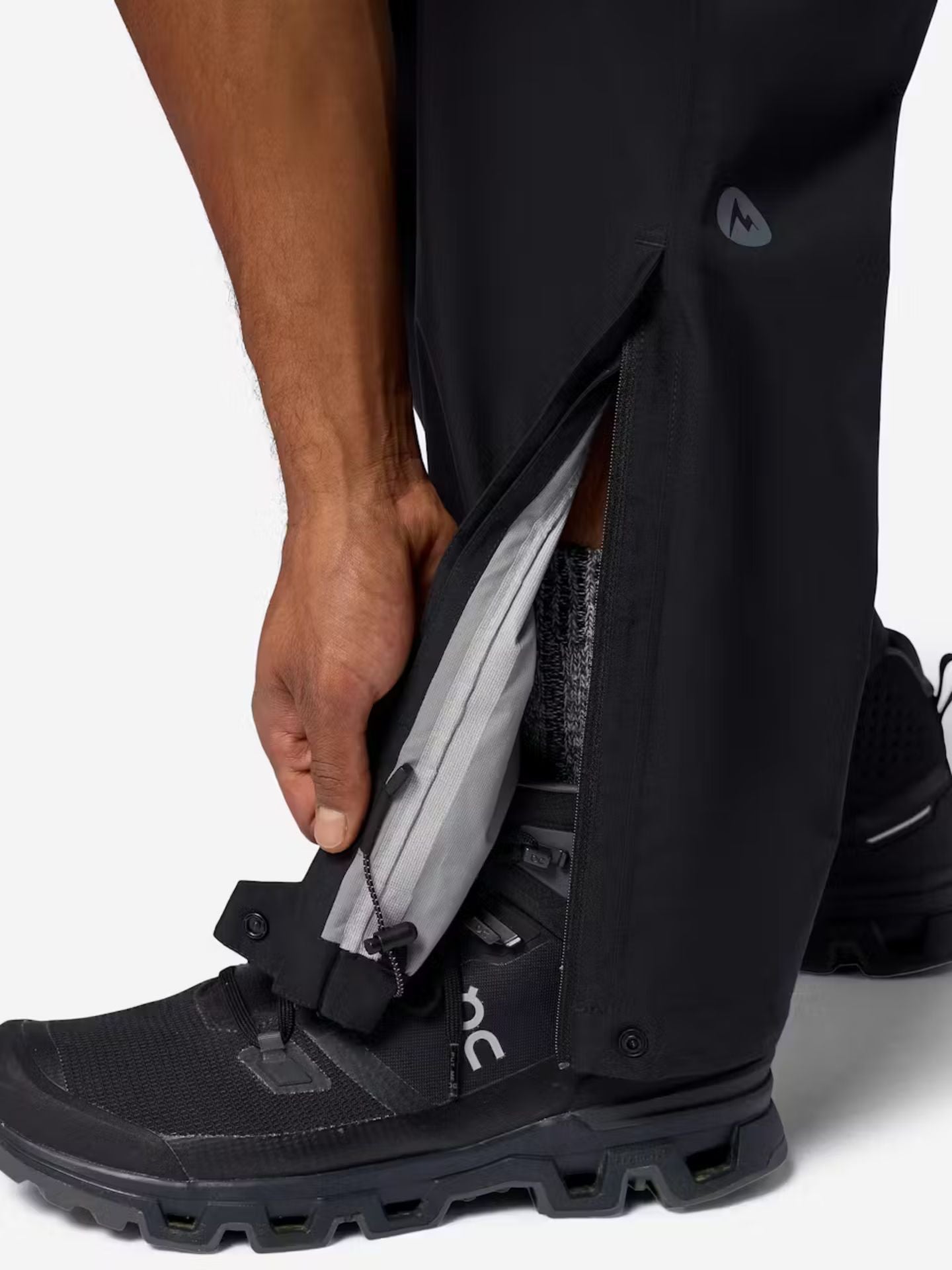 Black Marmot rain pants featuring a zipper at the ankle, as well as a cinchable cuff.