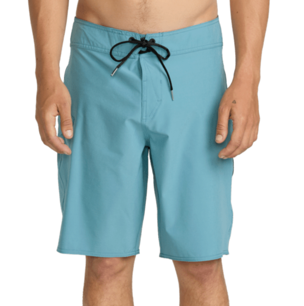 A man wearing light blue board shorts with a black drawstring, shown from the waist down against a plain white background.