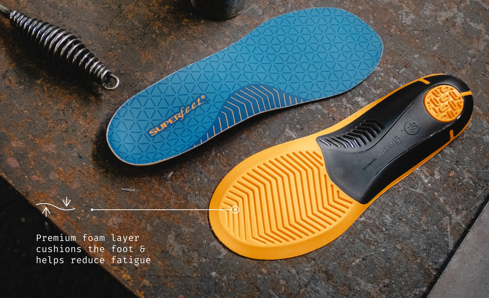 Blue and yellow shoe insole on a textured surface with Superfeet branding visible.